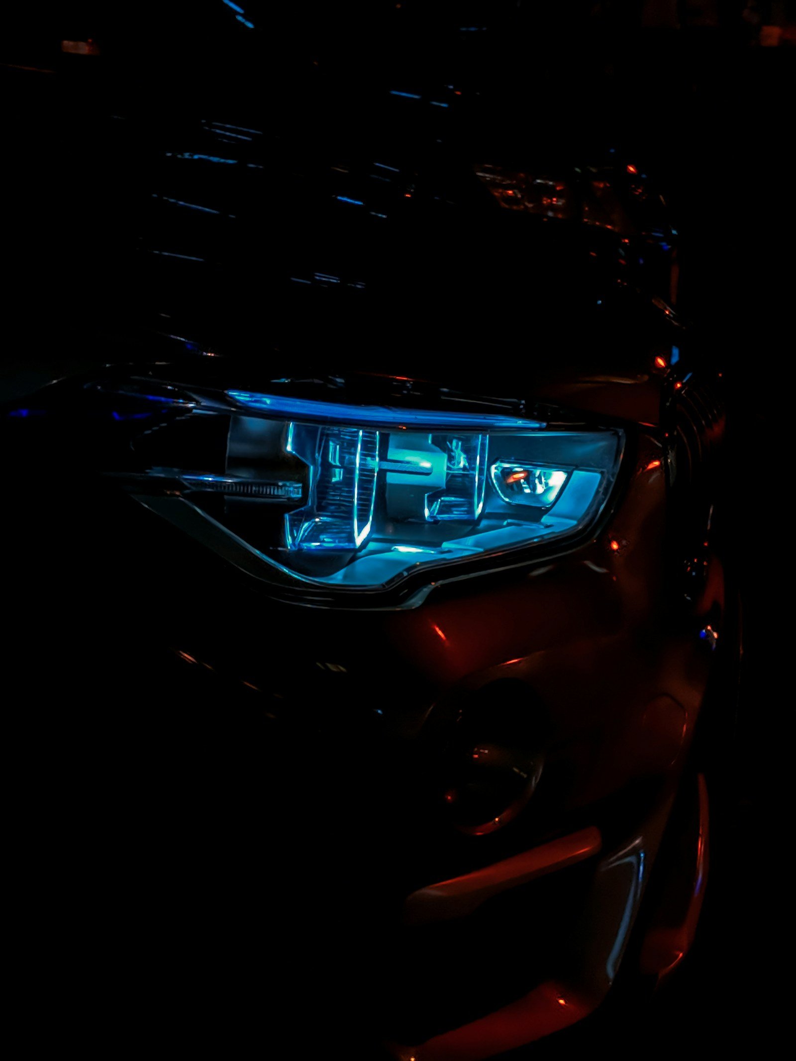 Editorial photograph of a headlight illuminated in blue